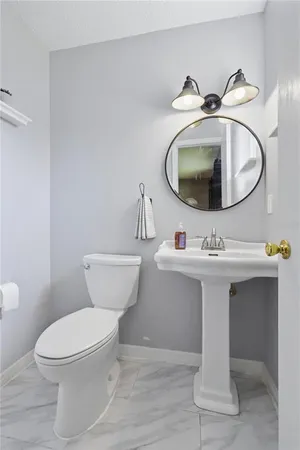 a bathroom with a sink toilet and mirror