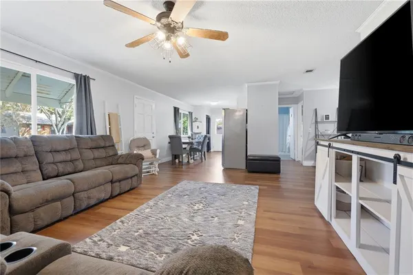 a living room with furniture flat screen tv and wooden floor