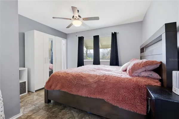 a bedroom with a bed chandelier and a window