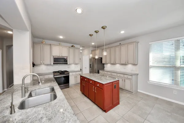 a kitchen with stainless steel appliances granite countertop a sink counter space cabinets and a large window