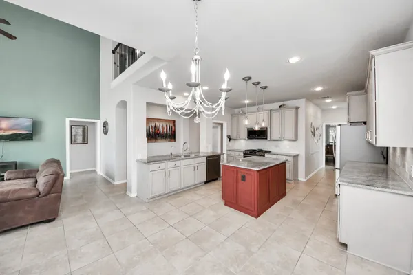 a large white kitchen with a large window and stainless steel appliances