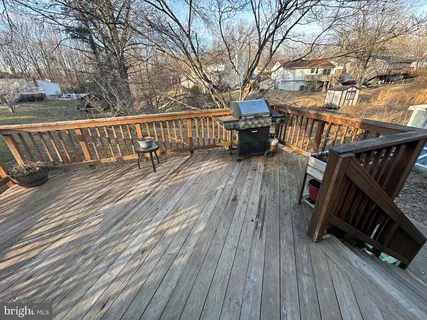 a balcony with wooden floor and outdoor seating