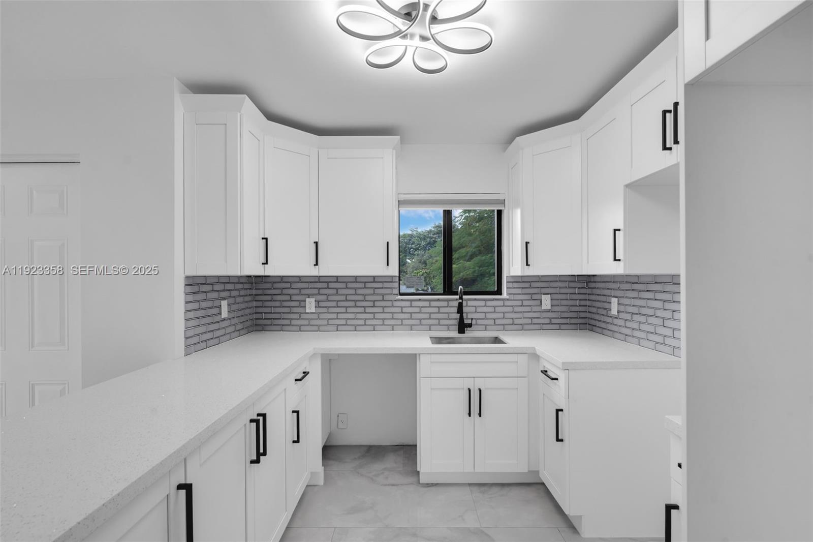 1413 Northwest 40th Street Miami, FL 33142 - Photo 10 of 30 a kitchen with white cabinets appliances and a sink