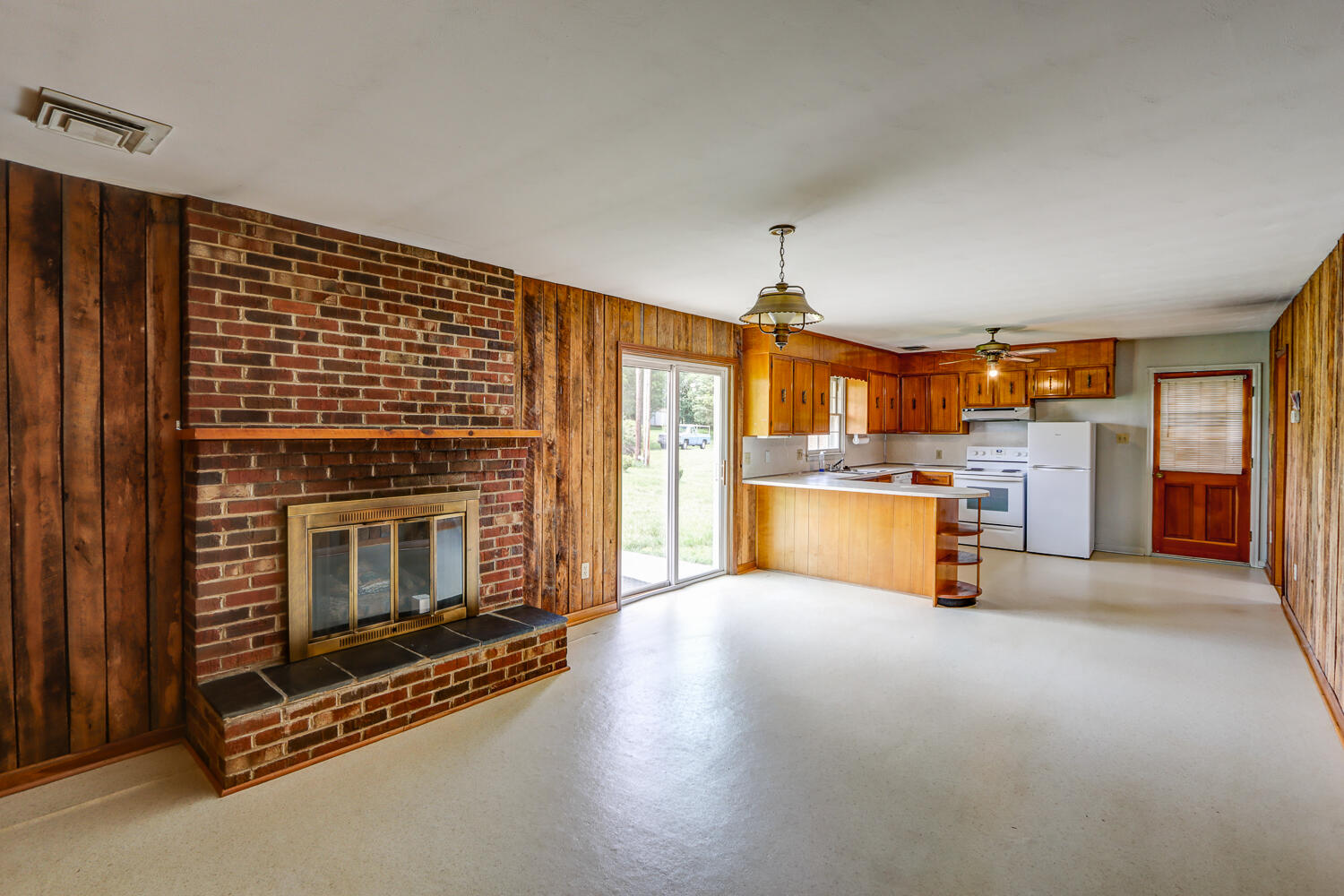 2231 Hardy Road Vinton, VA 24179 - Photo 18 of 40 a view of a kitchen with a stove wooden cabinets and a living room