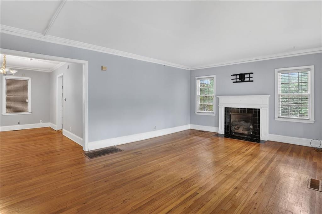 2728 Winburn Terrace Atlanta, GA 30344 - Photo 3 of 16 an empty room with wooden floor fireplace and windows