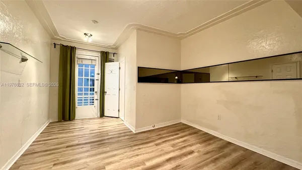 a view of a room with wooden floor and brick walls
