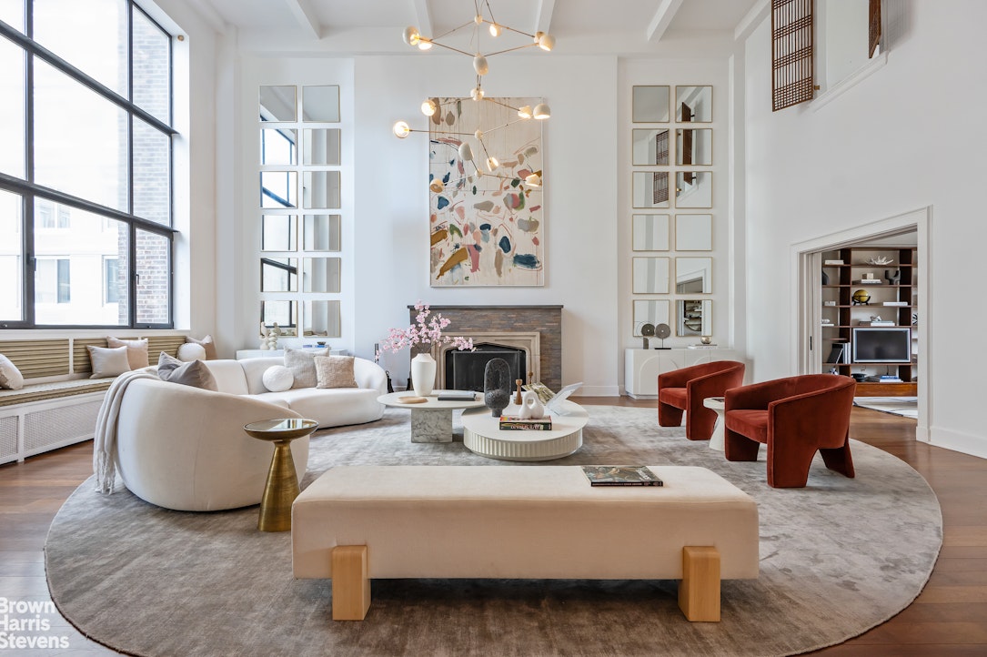 a living room with fireplace furniture and a large window