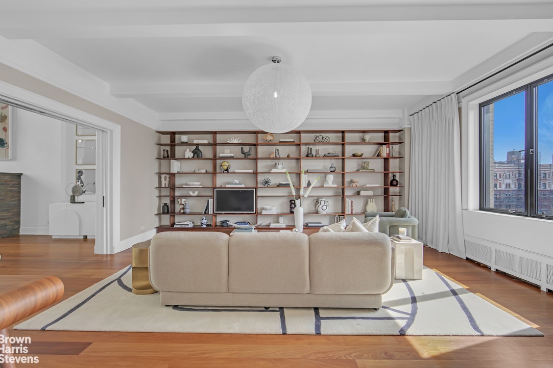 257 West 86th Street, Unit PHA Manhattan, NY 10024 - Photo 6 of 17 a living room with a couch and a book shelf