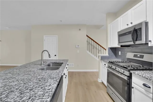 a kitchen with stainless steel appliances granite countertop a stove and a sink