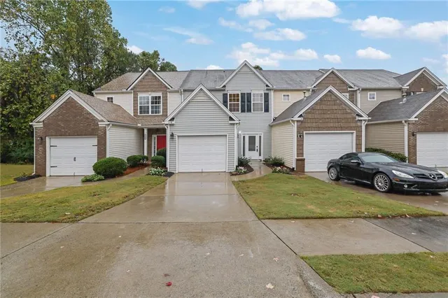 a view of a big house with a big yard and large trees