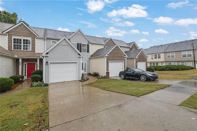 a view of a white house next to a yard and a yard