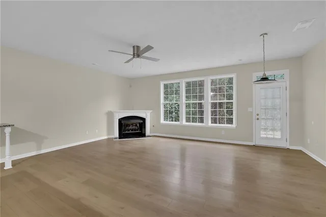 a view of an empty room with a window and fireplace