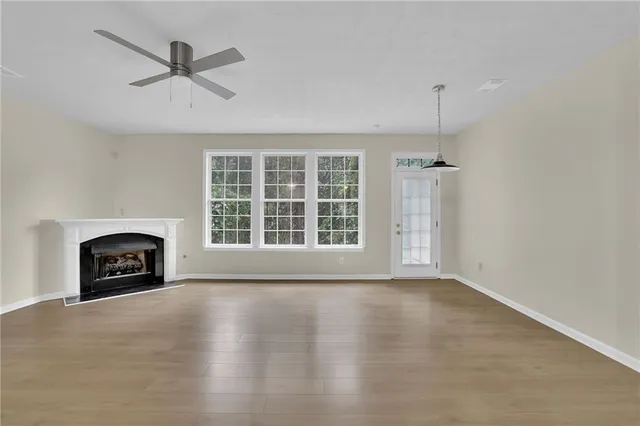 a view of an empty room with a fireplace and a window