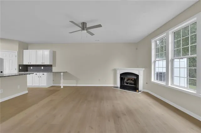 a view of an empty room with a window and fireplace