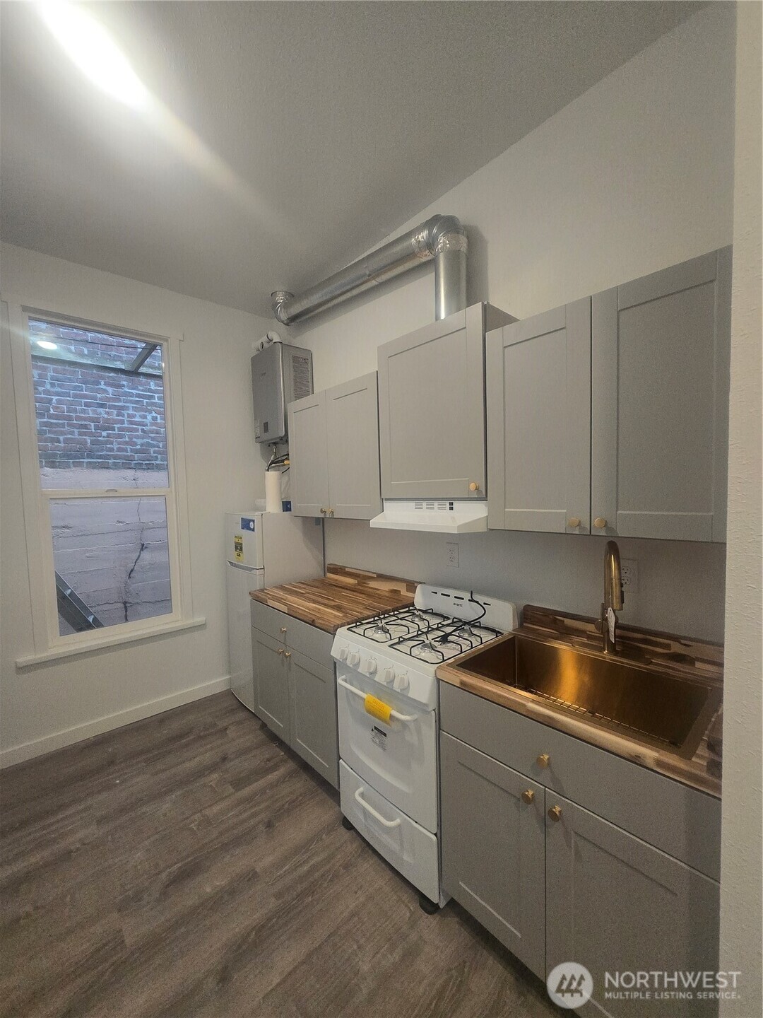 4332 University Way Northeast, Unit A Seattle, WA 98105 - Photo 6 of 20 a kitchen with a sink stove and cabinets