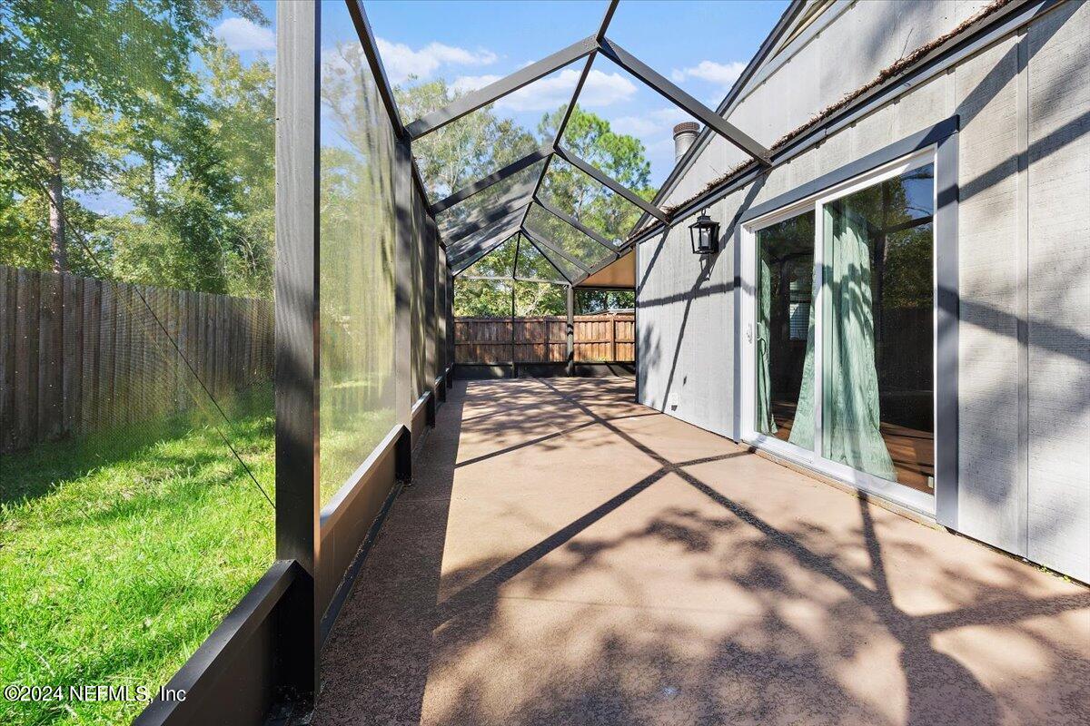 3176 Ricky Drive Jacksonville, FL 32223 - Photo 18 of 22 a view of a pathway of a house with a floor to ceiling window and wooden fence