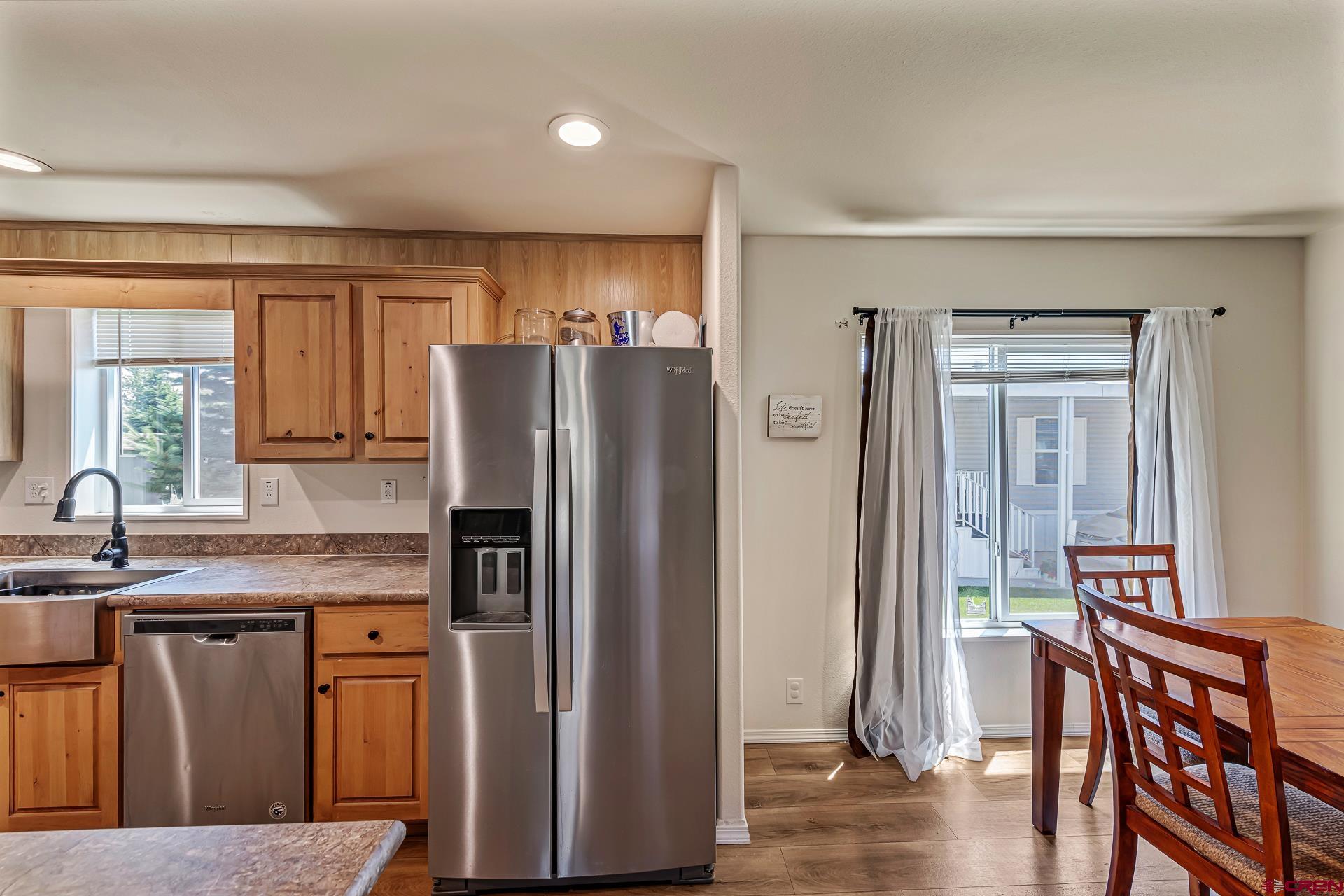 901 6530 Road, Unit 3007 Montrose, CO 81401 - Photo 12 of 33 a kitchen with stainless steel appliances granite countertop a refrigerator a stove a sink a dining table and chairs