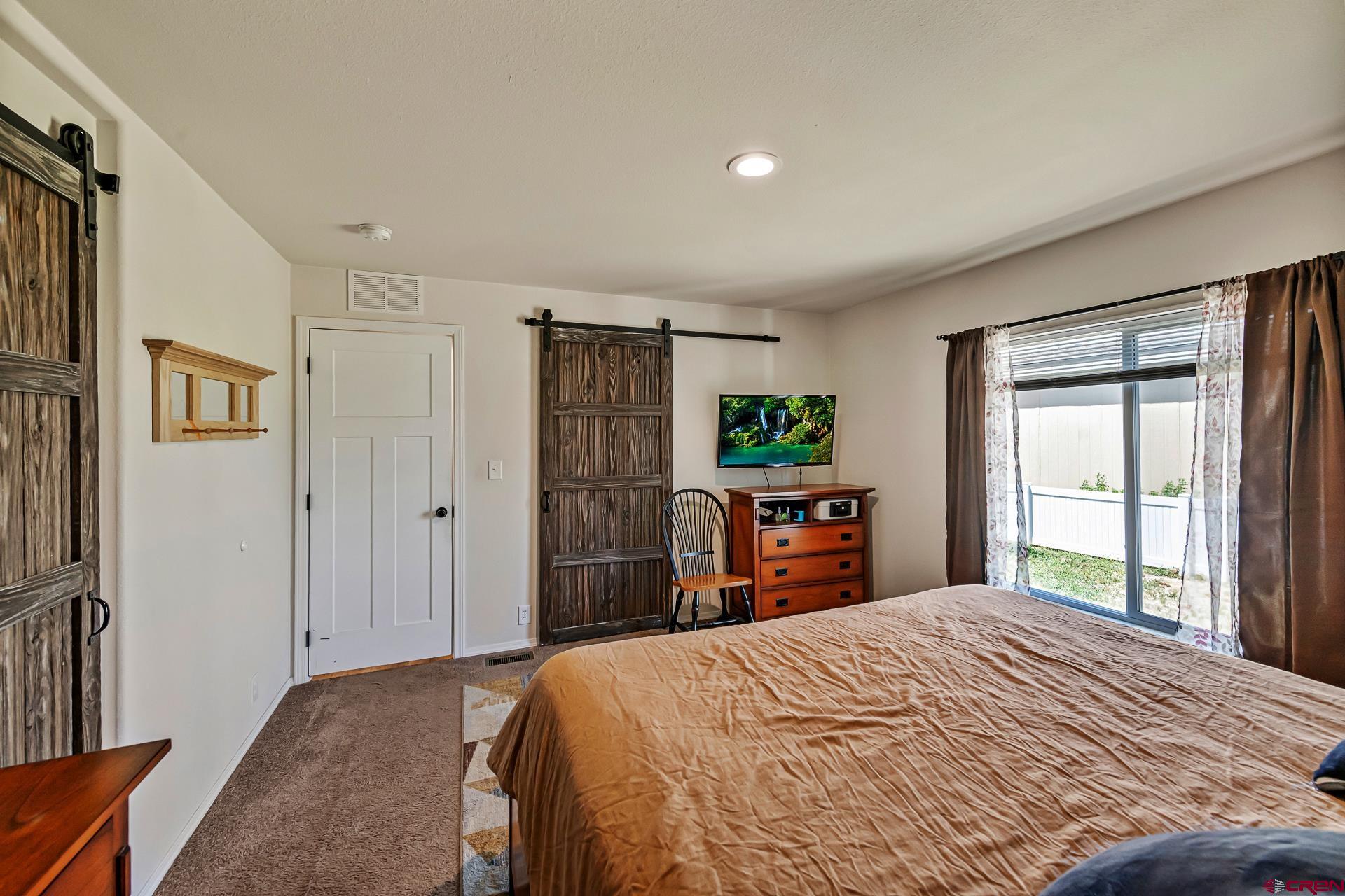901 6530 Road, Unit 3007 Montrose, CO 81401 - Photo 16 of 33 a bedroom with a bed and a dresser next to a window