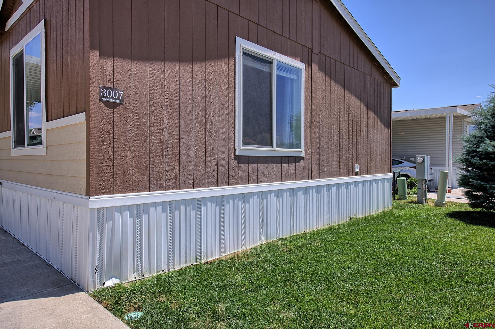 901 6530 Road, Unit 3007 Montrose, CO 81401 - Photo 2 of 33 a view of a backyard with plants and wooden fence