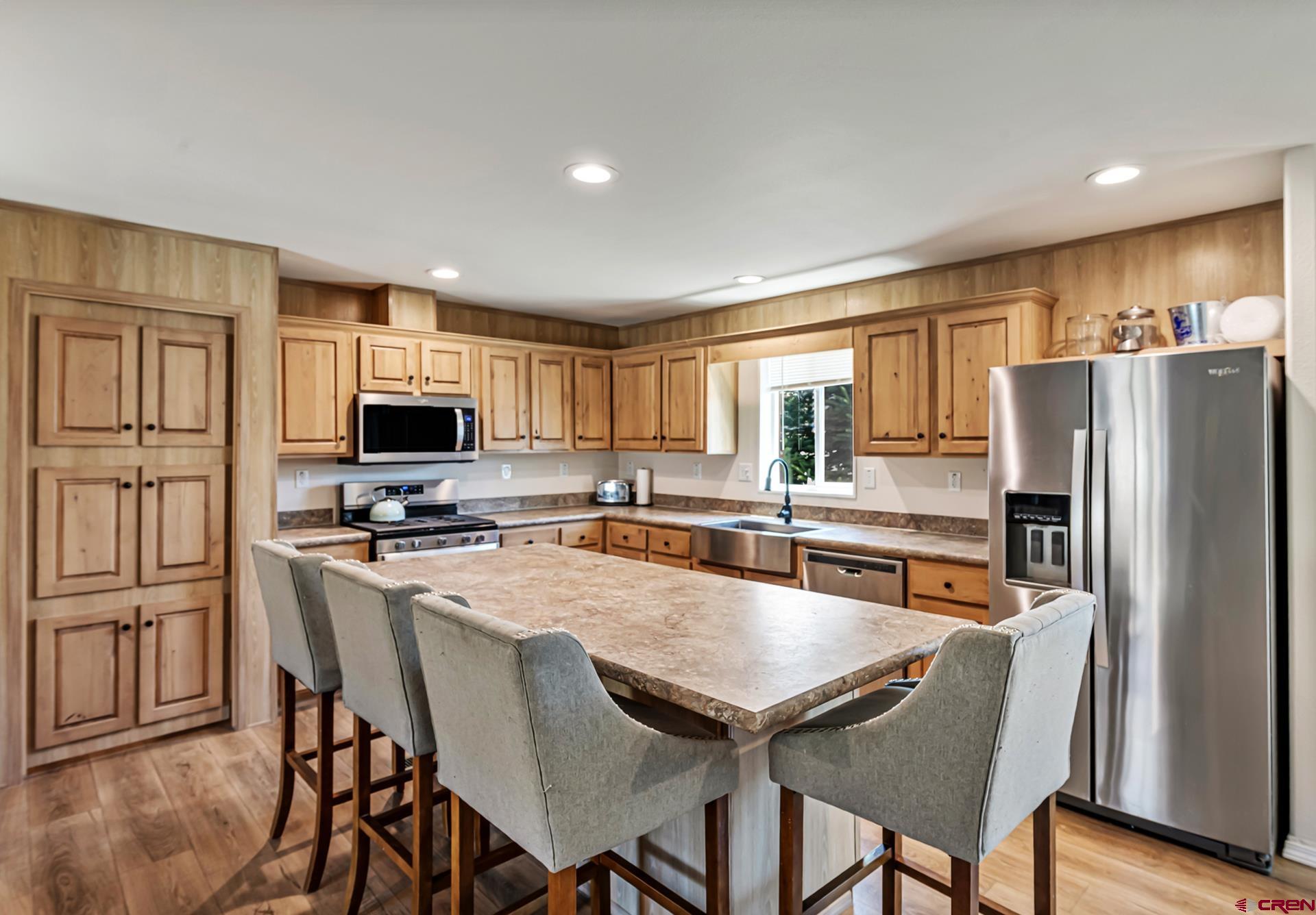 901 6530 Road, Unit 3007 Montrose, CO 81401 - Photo 8 of 33 a kitchen with stainless steel appliances a table chairs refrigerator and microwave