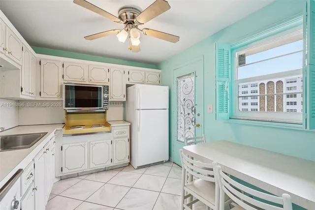 a kitchen with white cabinets and white appliances