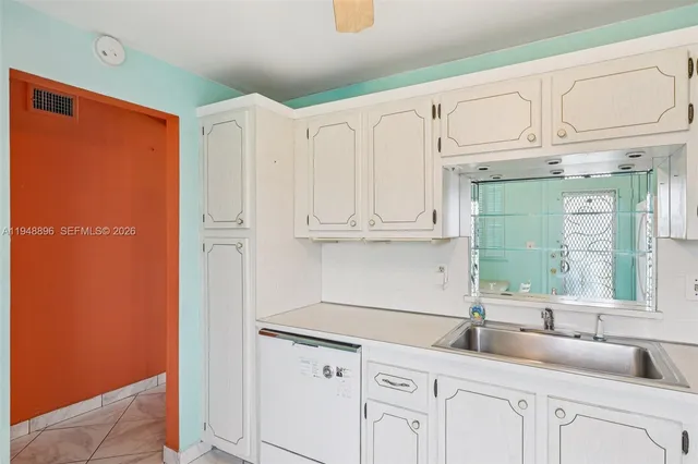 a kitchen with granite countertop white cabinets and white appliances