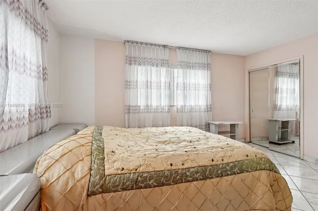 a bedroom with a bed and a large window