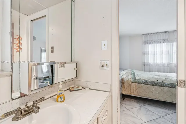 a en suite bathroom with a granite countertop tub and a sink