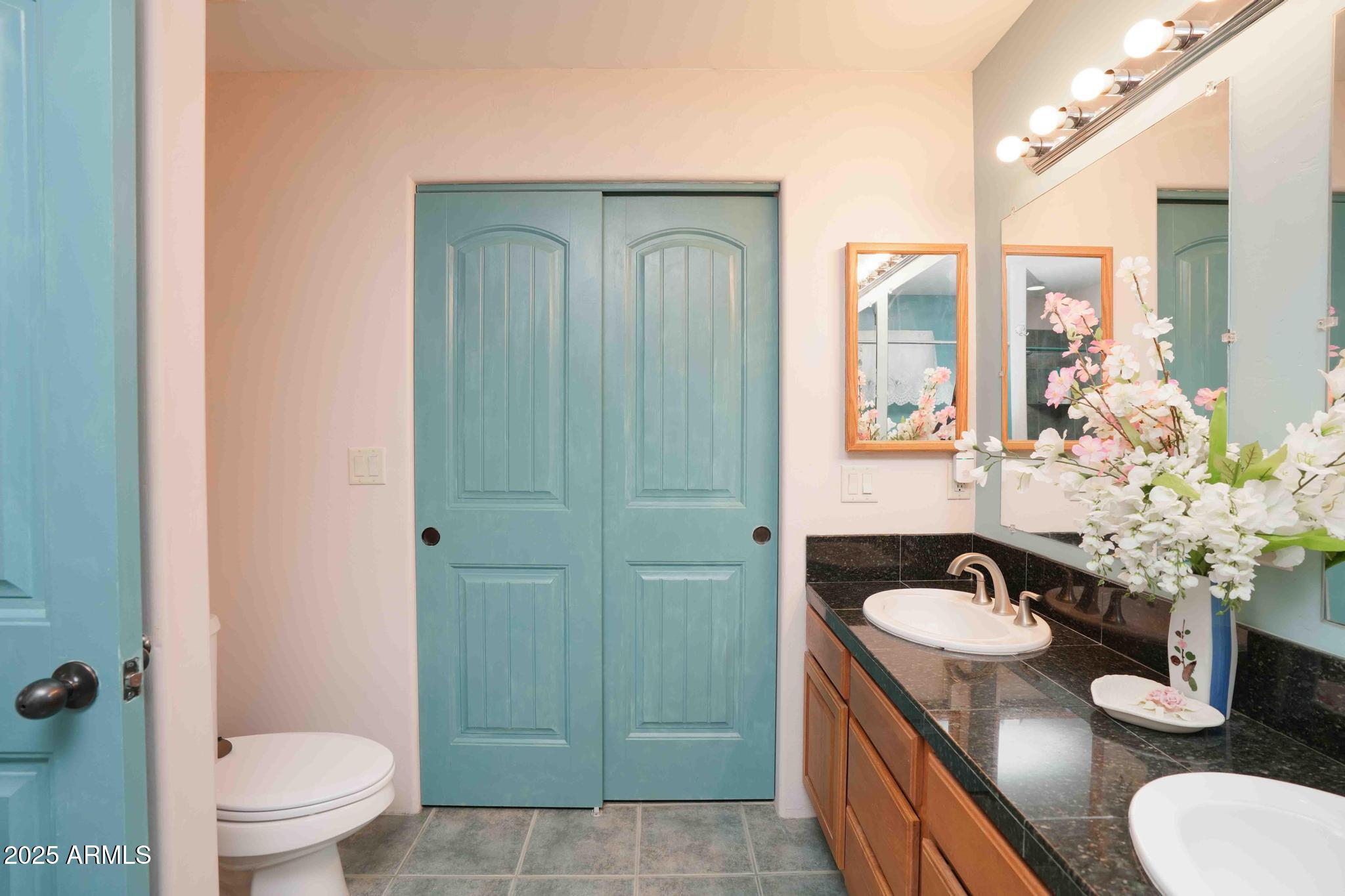 5775 North Kramer Drive Rimrock, AZ 86335 - Photo 19 of 33 a bathroom with a granite countertop sink a toilet a mirror and shower