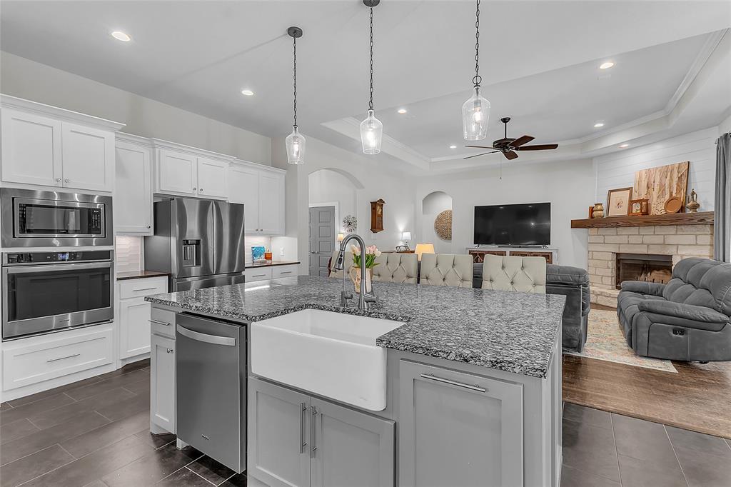 1014 Rennard Street Caddo Mills, TX 75135 - Photo 11 of 39 Large kitchen island with a farmhouse sink, granite countertop, and pendant lighting