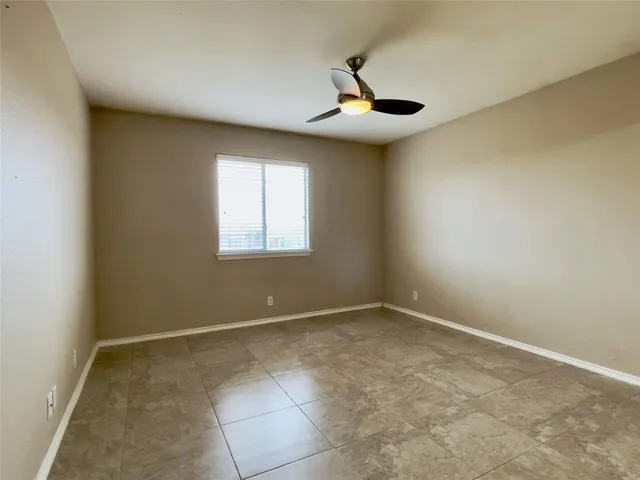 an empty room with chandelier fan