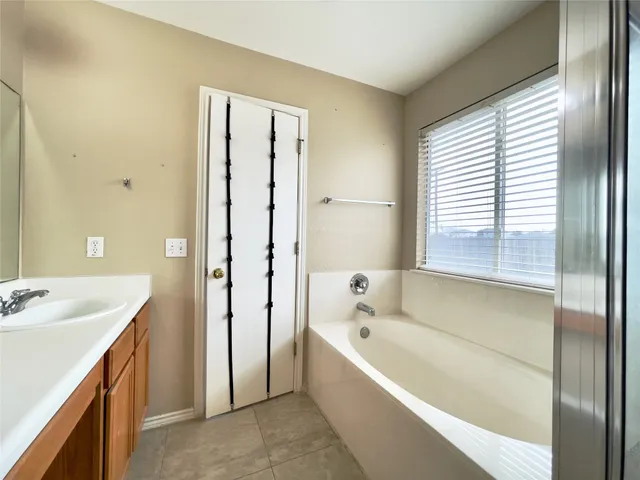 a bathroom with a tub sink and mirror