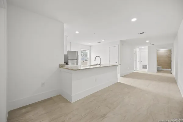 a view of kitchen with kitchen island wooden floor center island and stainless steel appliances
