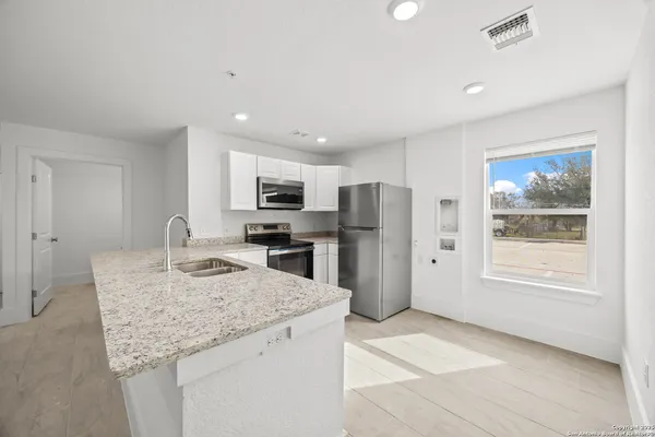 a kitchen with stainless steel appliances granite countertop a sink refrigerator and microwave