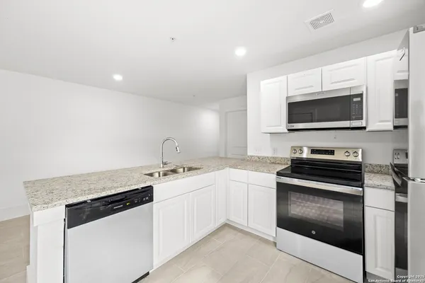 a kitchen with stainless steel appliances granite countertop a stove and a sink