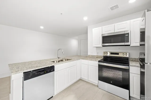 a kitchen with stainless steel appliances granite countertop a stove and a sink