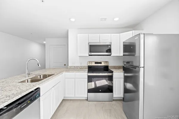 a kitchen with stainless steel appliances granite countertop a refrigerator sink and stove