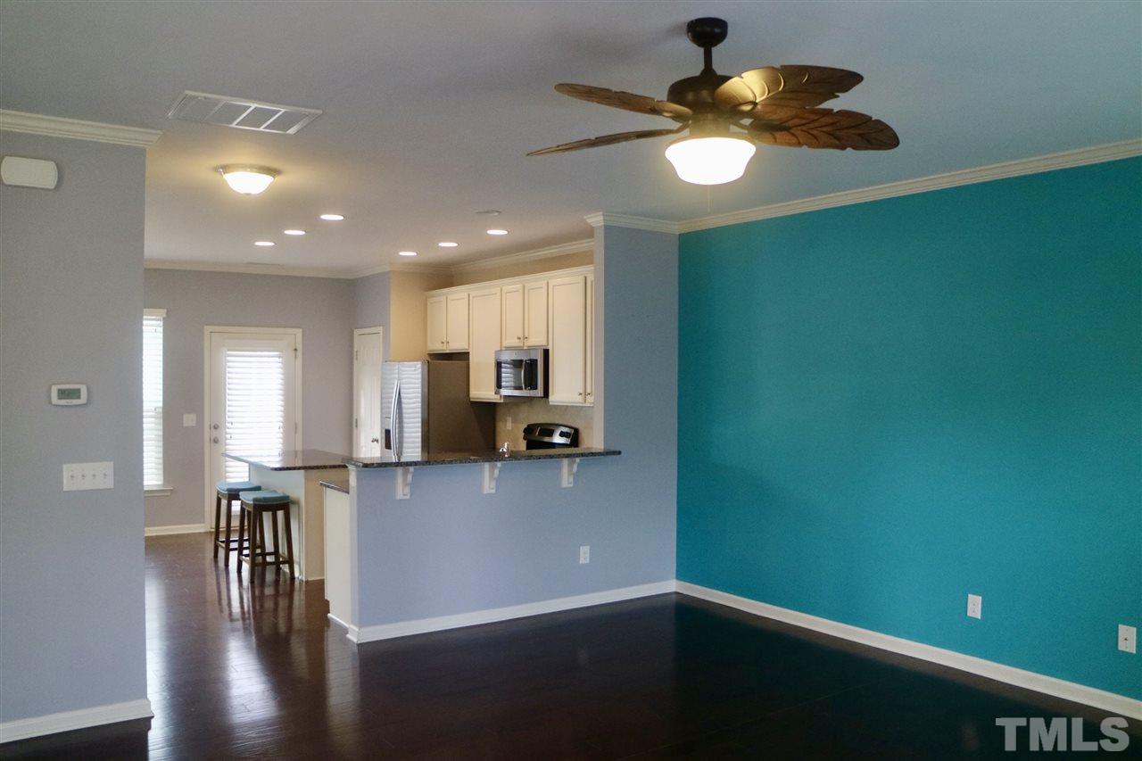 408 Provincial Street Raleigh, NC 27603 - Photo 4 of 24 a kitchen with kitchen island stainless steel appliances a table chairs in it and wooden floors