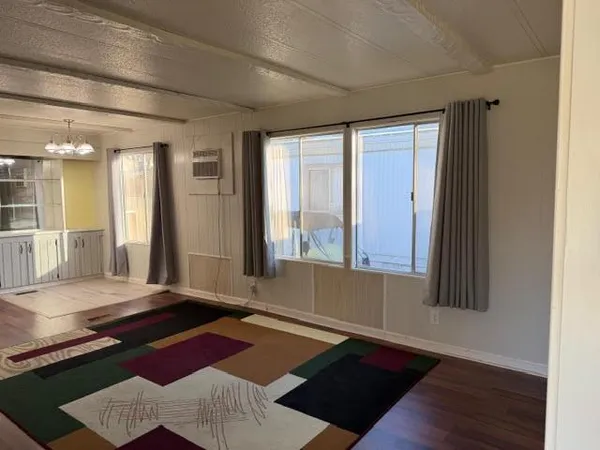 a view of a hallway view with wooden floor and chandelier