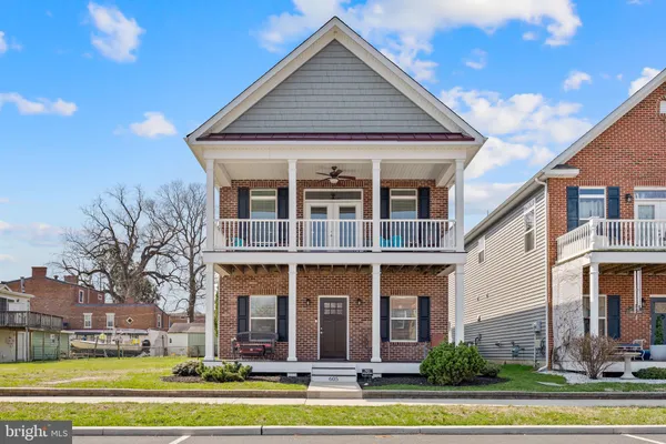 a view of a white house with a large windows and a table and chairs