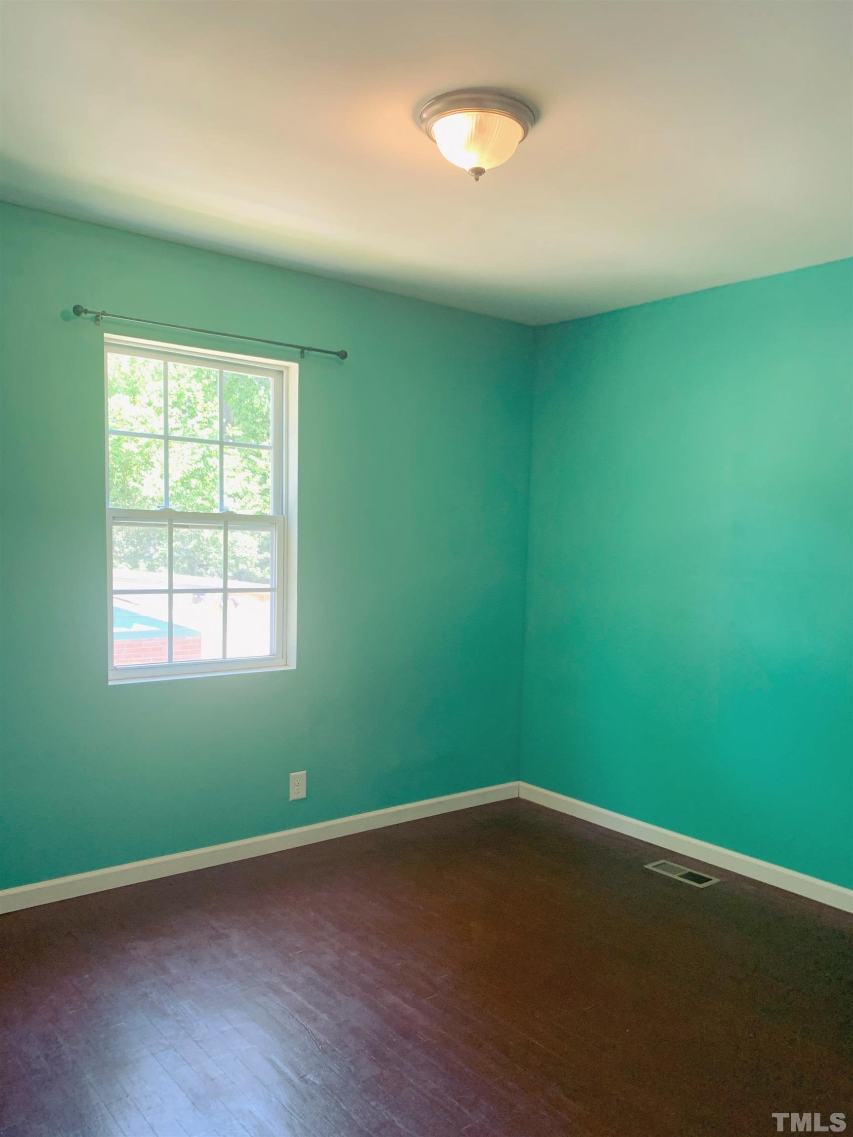 1804 Robinhood Road Durham, NC 27701 - Photo 10 of 25 an empty room with wooden floor and windows