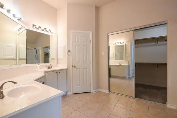 a spacious bathroom with a bathtub sink and mirror