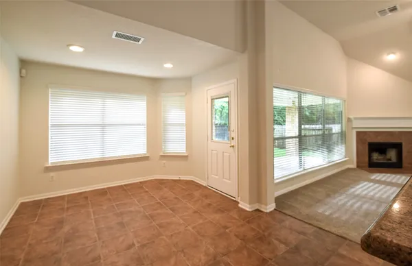 a view of an empty room with a fireplace and a window