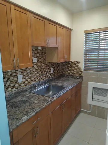 a kitchen with granite countertop a sink and a stove
