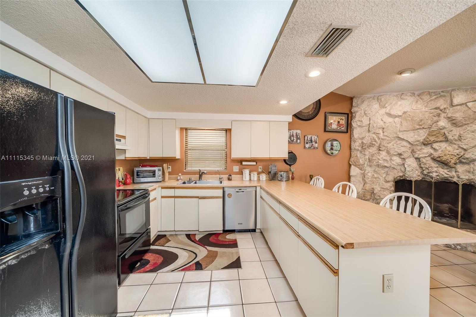 7921 Northwest 90th Avenue Tamarac, FL 33321 - Photo 15 of 69 a kitchen with a sink a refrigerator and cabinets