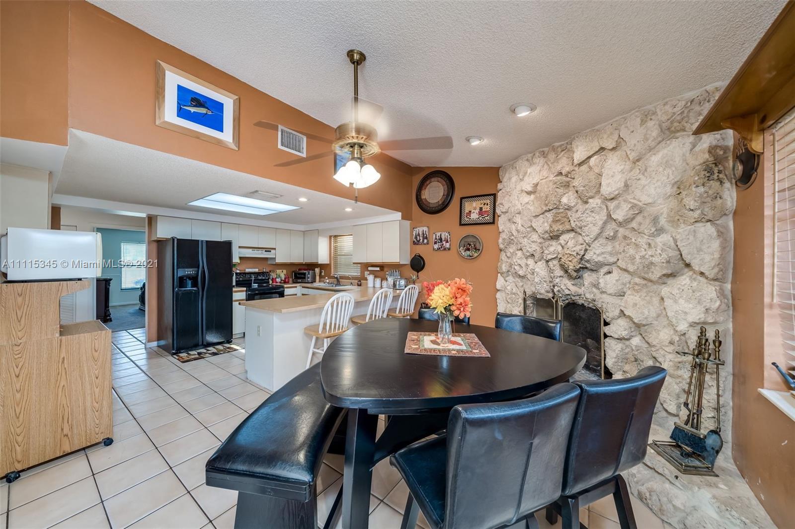 7921 Northwest 90th Avenue Tamarac, FL 33321 - Photo 22 of 69 a kitchen with stainless steel appliances a dining table and chairs with wooden floor
