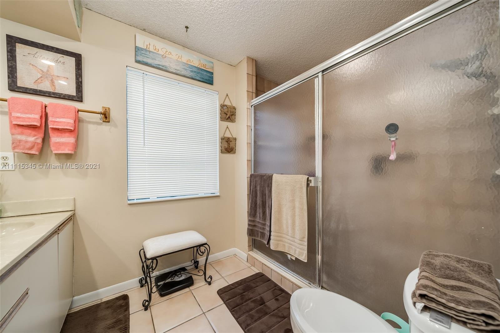 7921 Northwest 90th Avenue Tamarac, FL 33321 - Photo 31 of 69 a bathroom with a toilet a sink and a mirror