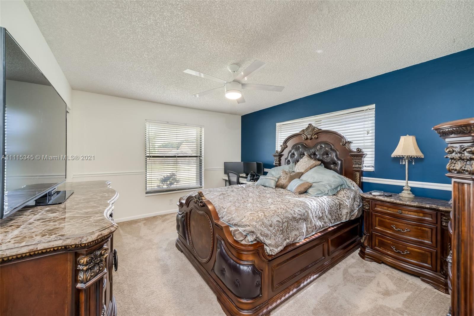 7921 Northwest 90th Avenue Tamarac, FL 33321 - Photo 32 of 69 a bedroom with a bed and wooden floor