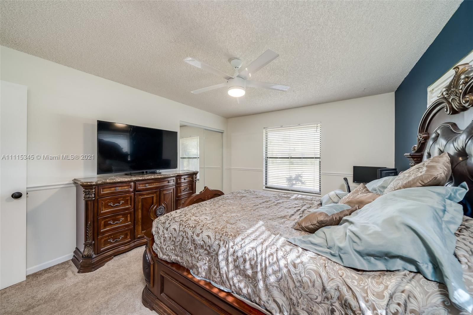 7921 Northwest 90th Avenue Tamarac, FL 33321 - Photo 34 of 69 a bedroom with a bed and a flat screen tv