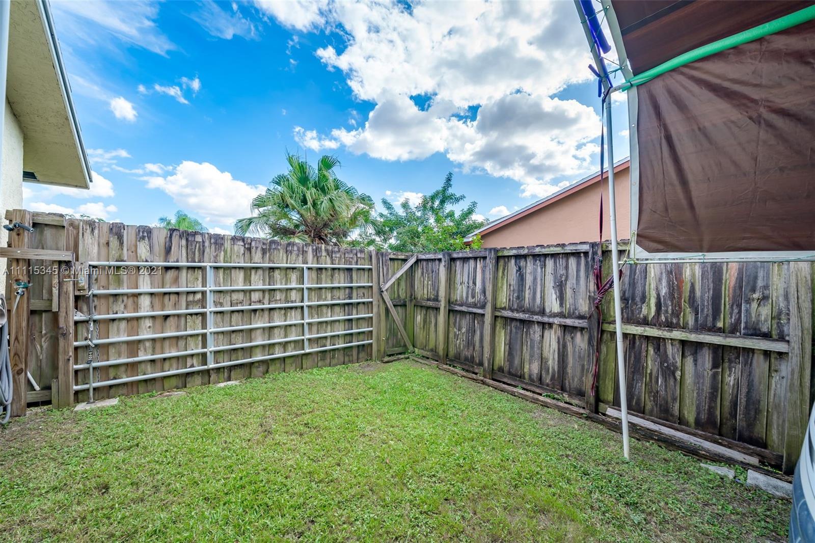 7921 Northwest 90th Avenue Tamarac, FL 33321 - Photo 50 of 69 a view of backyard with wooden fence and large trees